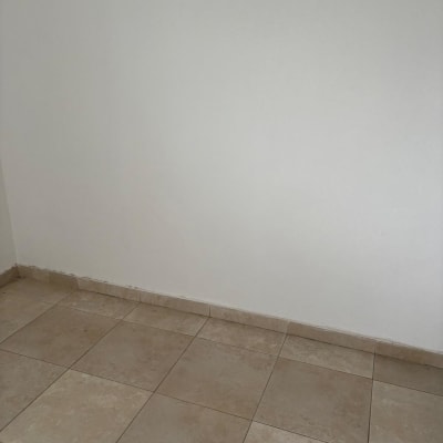 רצפה ריקה עם אריחים בהירים וקיר לבן