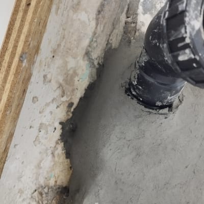 צינור שחור מותקן בקיר עם בטון רטוב
