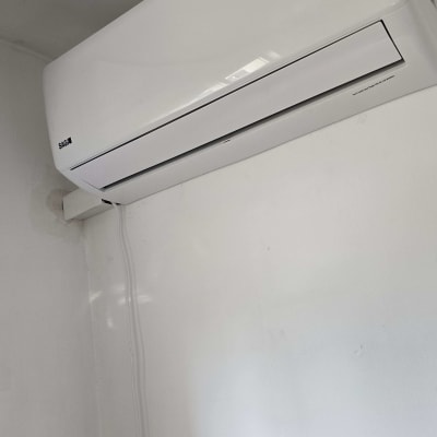 מזגן קיר לבן מותקן על קיר לבן