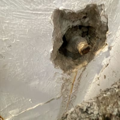 צינור חלוד בקיר עם חור בטיח