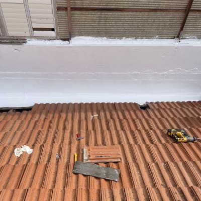 כלי עבודה על גג רעפים אדום עם מקדחה