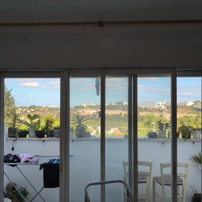 חלון עם תריסים ונוף חיצוני