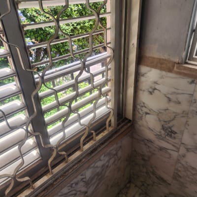 סורגי חלון מתכתיים ליד קיר שיש