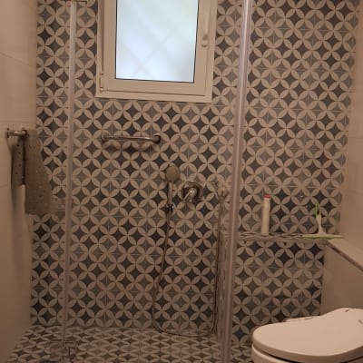 מקלחון זכוכית עם דלתות שקופות בחדר אמבטיה