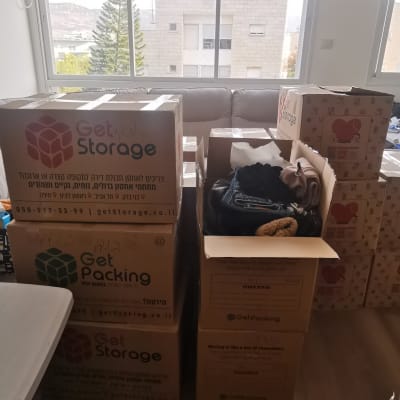 קופסאות אריזה בחדר עם בגדים לאריזה