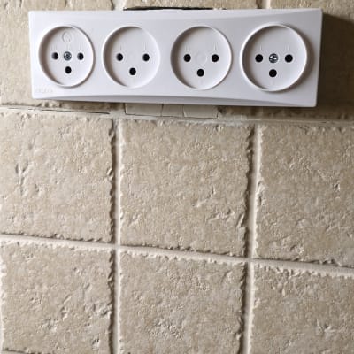 שלושה שקעים חשמליים על קיר מרוצף