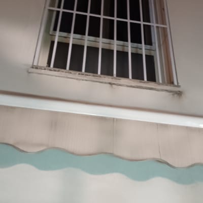 חלון עם סורגים על קיר חיצוני של בניין