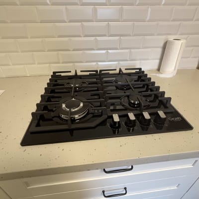 כיריים גז על משטח מטבח עם אריחי קיר לבנים