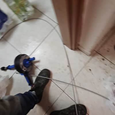 כלי עבודה של אינסטלטור על רצפה עם כבל מתכת