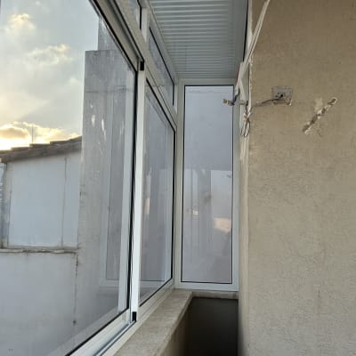 חלונות אלומיניום במרפסת סגורה עם קיר חיצוני