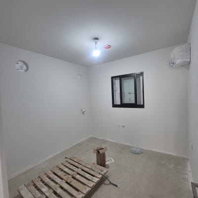 חדר ריק עם קירות צבועים ומשטח עץ על הרצפה