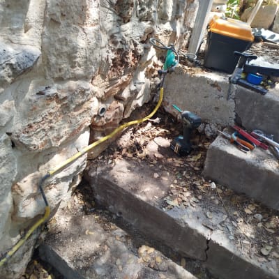 כלים ועבודות גז ליד קיר אבן