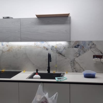 מטבח בשיפוץ עם אריחים חדשים, כיור וברז מותקנים.