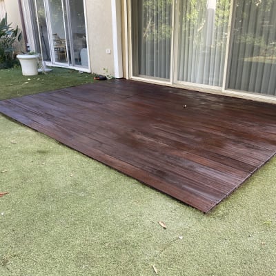 wooden deck on artificial grass near sliding glass doors