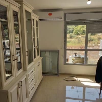 מזגן מותקן על קיר מעל חלון עם נוף חיצוני