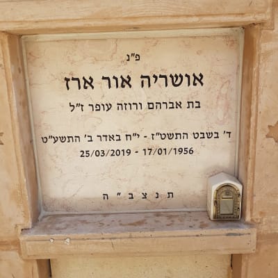 מצבה עם כיתוב בעברית ונרות זיכרון