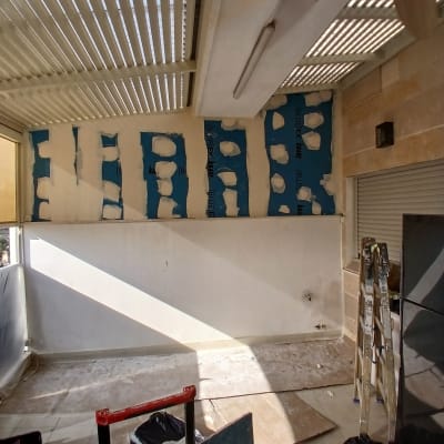 קיר עם לוחות גבס בתהליך התקנה ושיפוץ