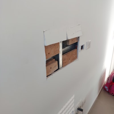 חור בקיר עם עץ וחשמל חשוף