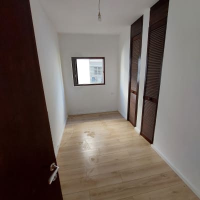 חדר ריק עם קירות לבנים ורצפת עץ