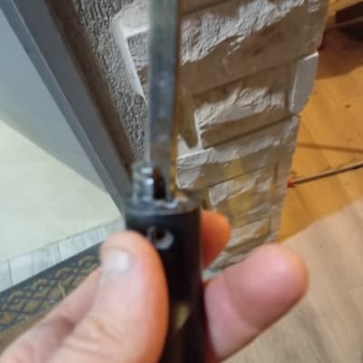 כלי עבודה עם ידית שחורה ליד קיר לבנים