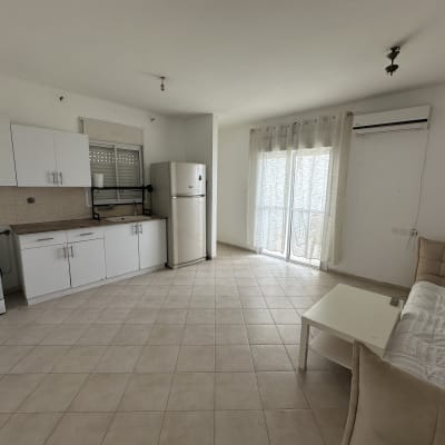 מטבח וסלון בדירה ריקה עם ריהוט בסיסי