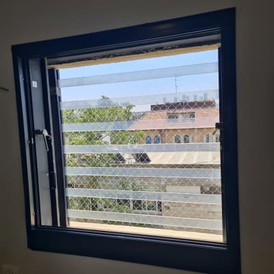 רשת מתכת על חלון למניעת כניסת יונים