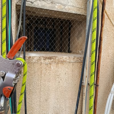 רשת מתכת על חלון עם חבלים וכלים