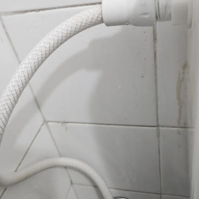 חיבור צינור מים גמיש לברז ניל בקיר מרוצף אריחים לבנים