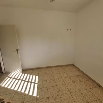 חדר ריק עם רצפת אריחים ודלת פתוחה