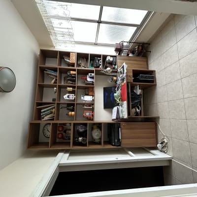 חדר עם מדפים, שולחן ומנורה על הקיר