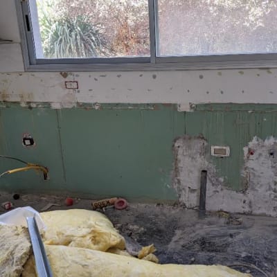 קיר מטבח עם צינורות חשופים ושקעי חשמל