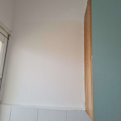 קיר צבוע חלקית בצבע לבן ליד ארון מטבח