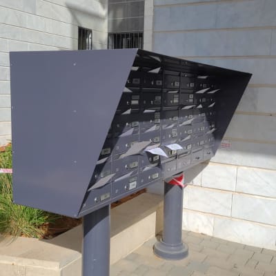 תיבות דואר מתכתיות על עמודים במבנה חיצוני