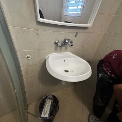 כיור עם דלי וכלי איטום על הרצפה