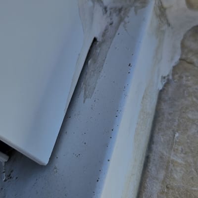 חומר איטום לבן על פינה של קיר מתקלף