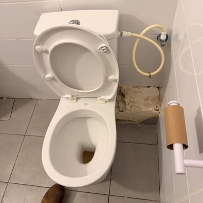 אסלה עם חיבורי מים בחדר אמבטיה