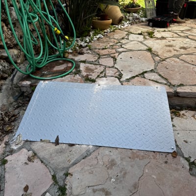 פלטת מתכת על רצפת אבן בחצר