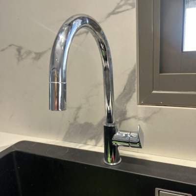 ברז כרום מעל כיור שחור במטבח