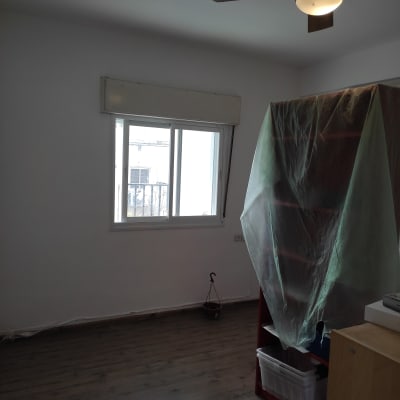 חדר עם קיר צבוע, רהיטים מכוסים בניילון