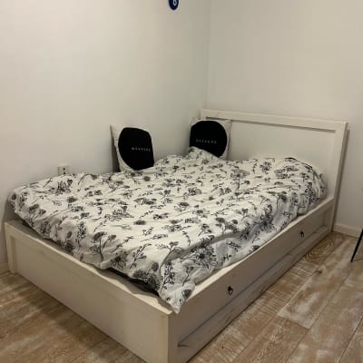 מיטה עם מצעים פרחוניים בחדר שינה פשוט