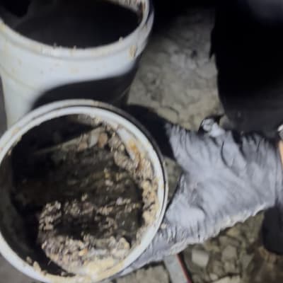 ידיים עם כפפות מחזיקות צינור פתוח עם לכלוך