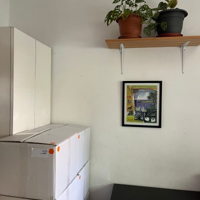 קופסאות קרטון מסודרות על שולחן ליד ארון לבן