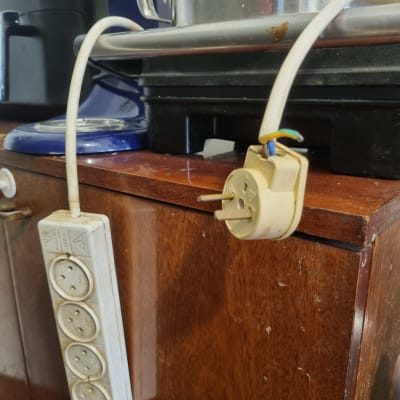 כבל חשמל עם תקע ושקע חשמל על שולחן עץ