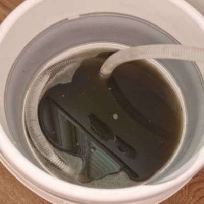 דלי עם צינור ומים כהים, קשור למיזוג אוויר