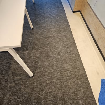 שטיח אפור על רצפה ליד שולחן לבן