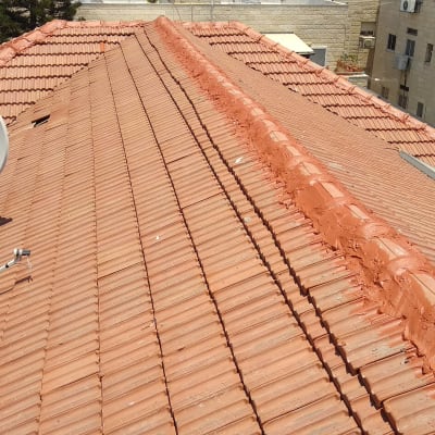 גג רעפים אדום עם צלחות לוויין מותקנות עליו