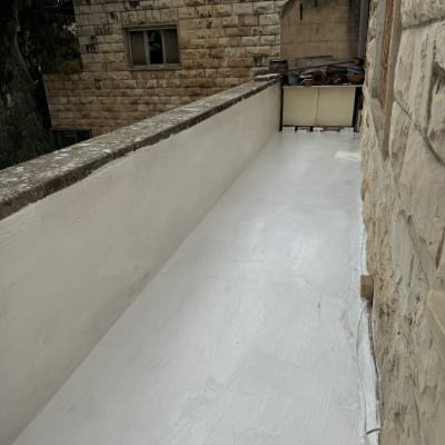 מרפסת אטומה בצבע לבן עם קירות אבן