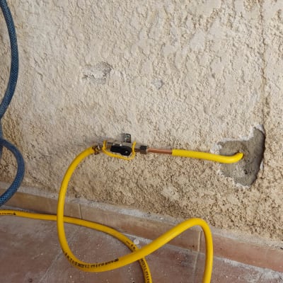 צינור גז צהוב מחובר לשסתום על קיר