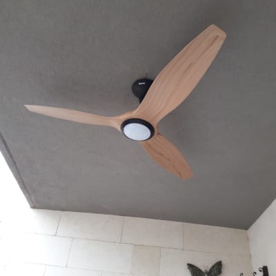 מאוורר תקרה עם שלוש כנפיים מעץ מותקן על תקרה אפורה