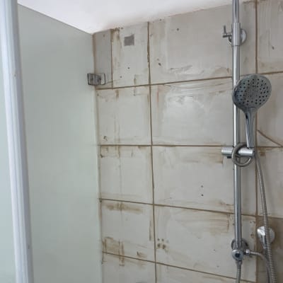 מקלחת עם אריחים, ראש מקלחת וצינור מתכת